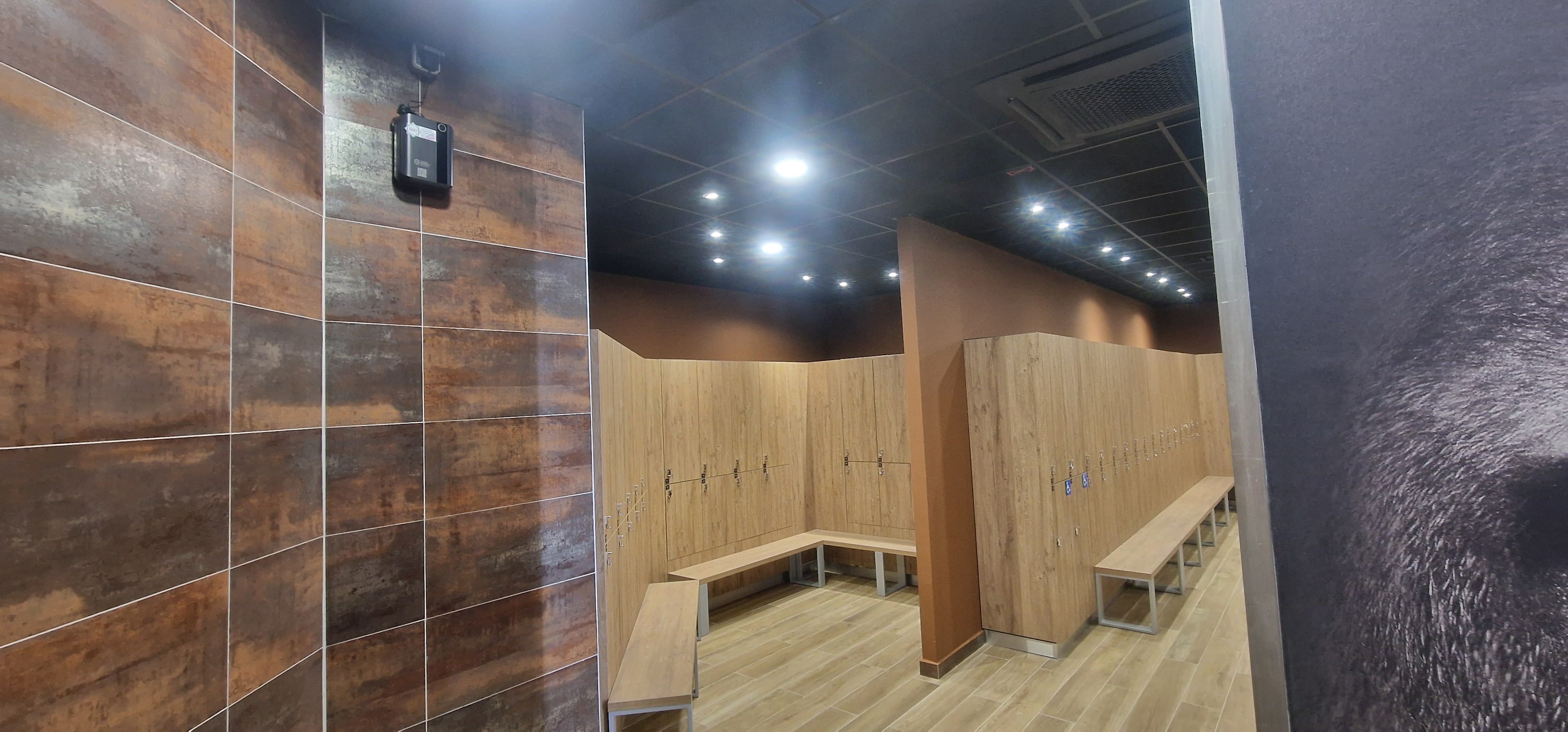 Vestiaires avec casiers en bois, bancs et diffuseur mural
